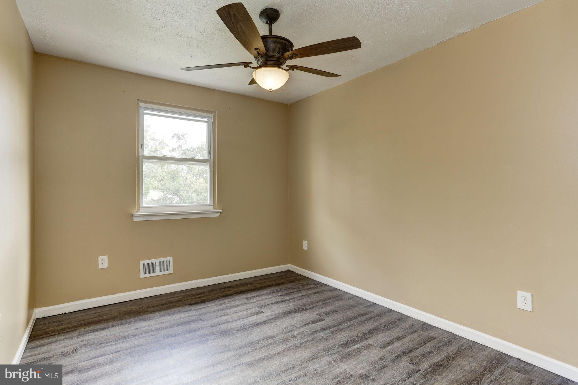 1925 Addison Road South District Heights, MD 20747 - Photo 9 of 9 an empty room with wooden floor and windows