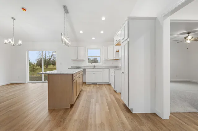 a view of a kitchen with wooden floor and a window