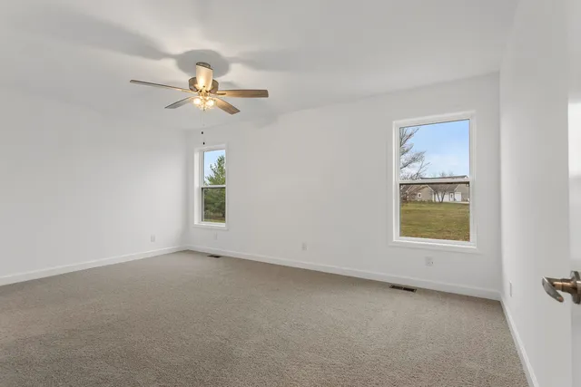 an empty room with a window and a ceiling fan