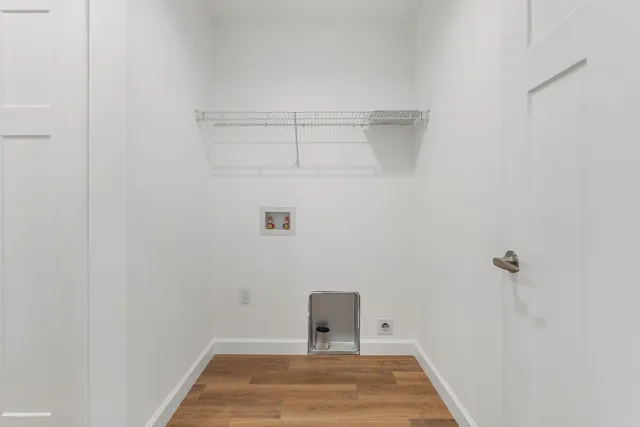 a view of a hallway with wooden floor and closet area