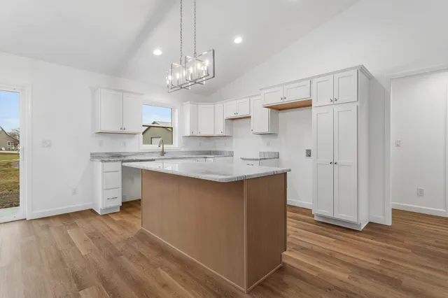 a kitchen with granite countertop white cabinets white appliances and sink