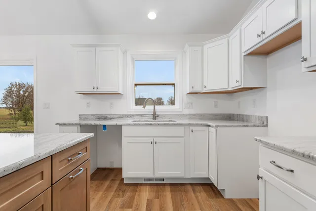 a kitchen with white cabinets and a sink