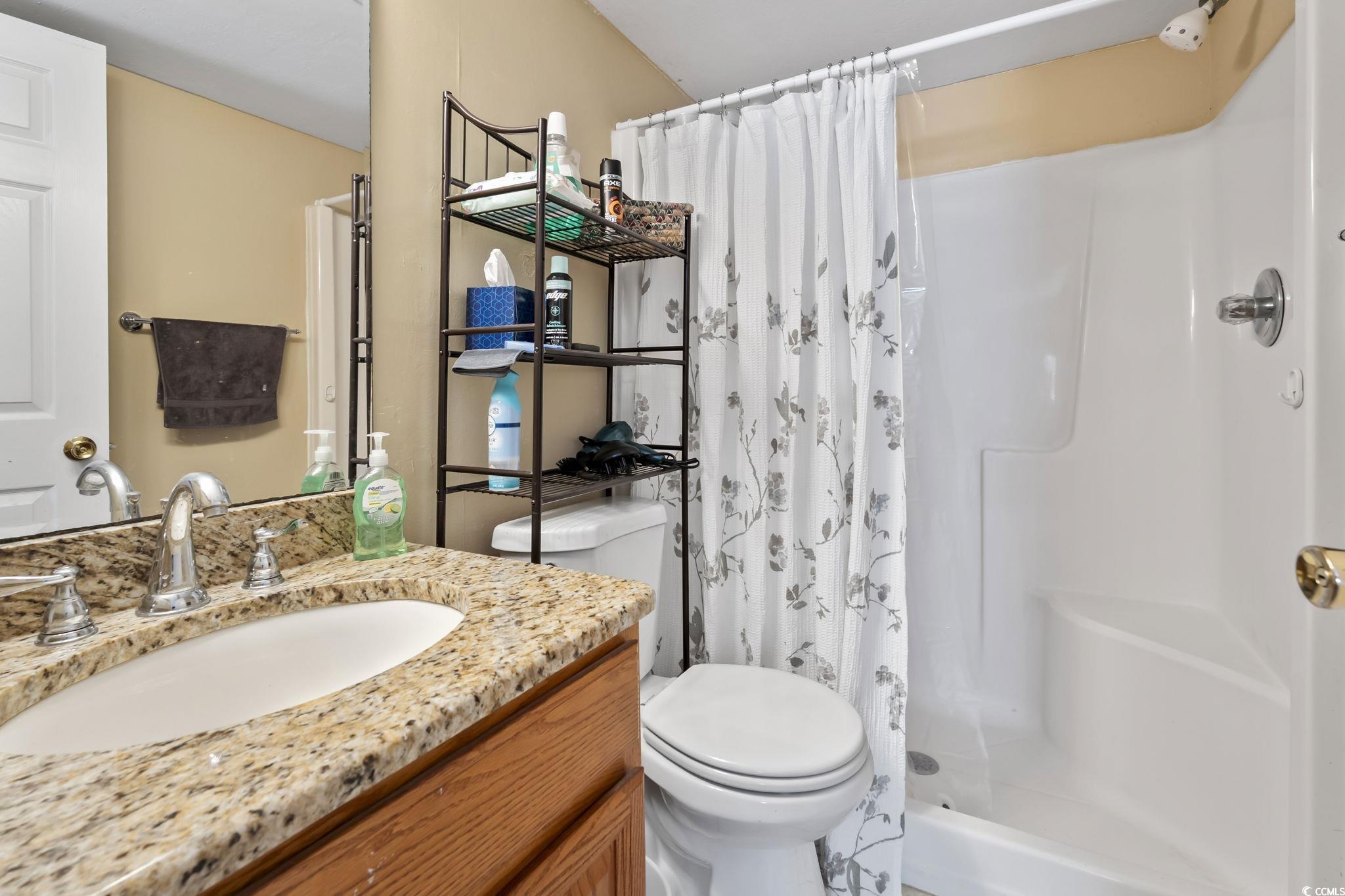 1301 Pridgen Road, Unit 304 Myrtle Beach, SC 29577 - Photo 17 of 26 Bedroom featuring light carpet, a walk in closet, and ensuite bath