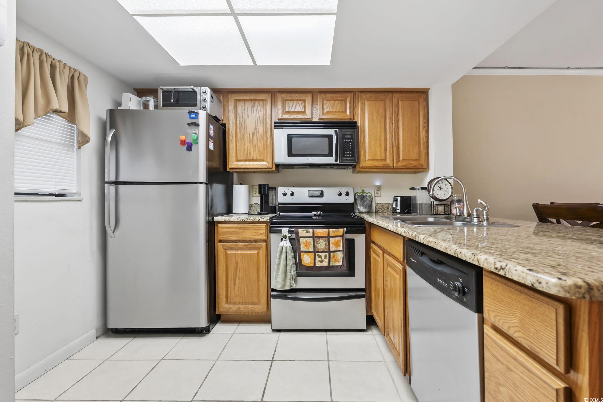 1301 Pridgen Road, Unit 304 Myrtle Beach, SC 29577 - Photo 7 of 26 Kitchen featuring appliances with stainless steel finishes and brown cabinetry