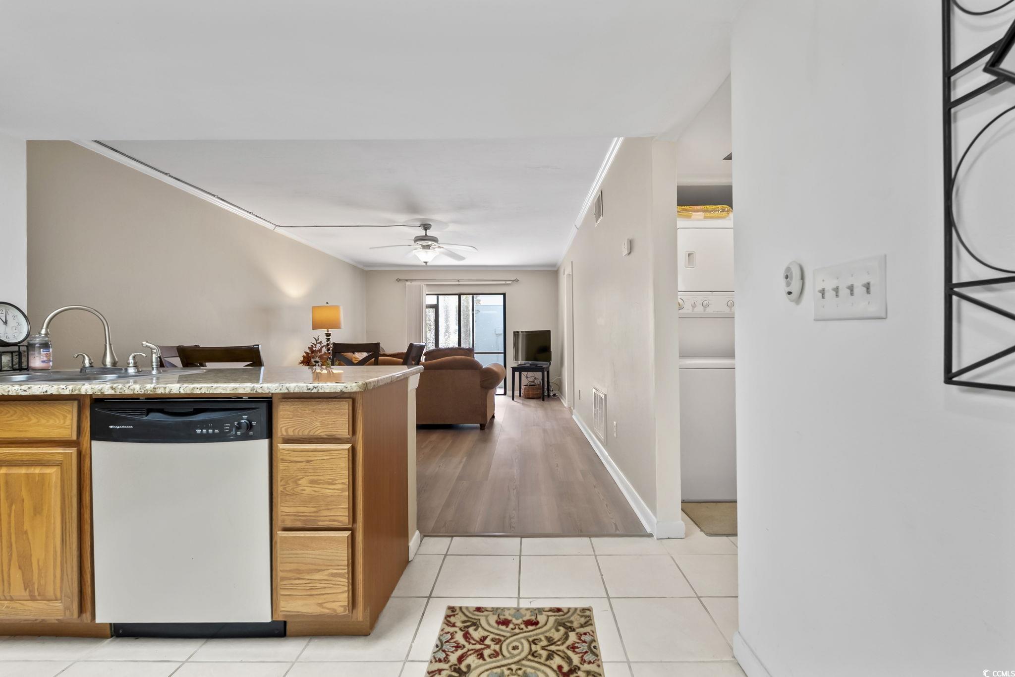 1301 Pridgen Road, Unit 304 Myrtle Beach, SC 29577 - Photo 25 of 26 Kitchen featuring stainless steel appliances, a peninsula, brown cabinetry, open floor plan, and light tile patterned flooring