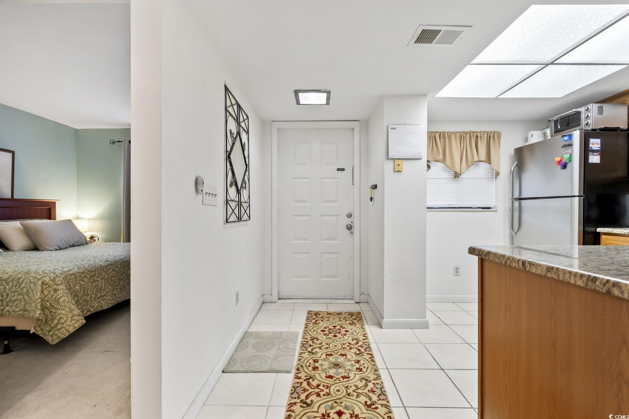 1301 Pridgen Road, Unit 304 Myrtle Beach, SC 29577 - Photo 26 of 26 Kitchen featuring brown cabinets, stainless steel dishwasher, light tile patterned floors, a ceiling fan, and open floor plan