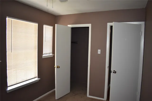 an empty room with closet and wooden floor