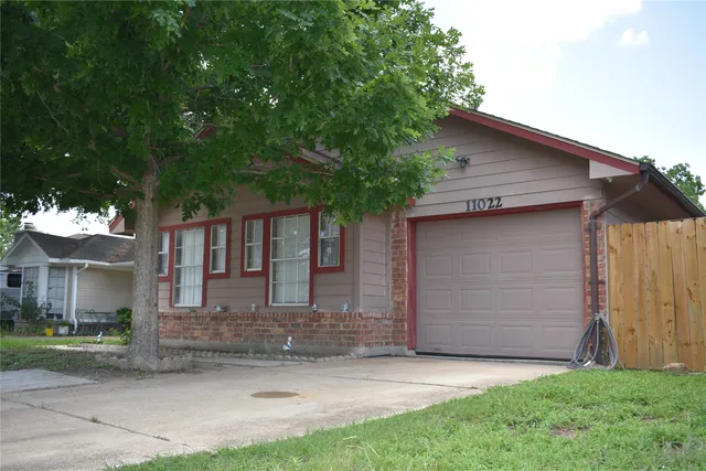 a front view of a house with a tree