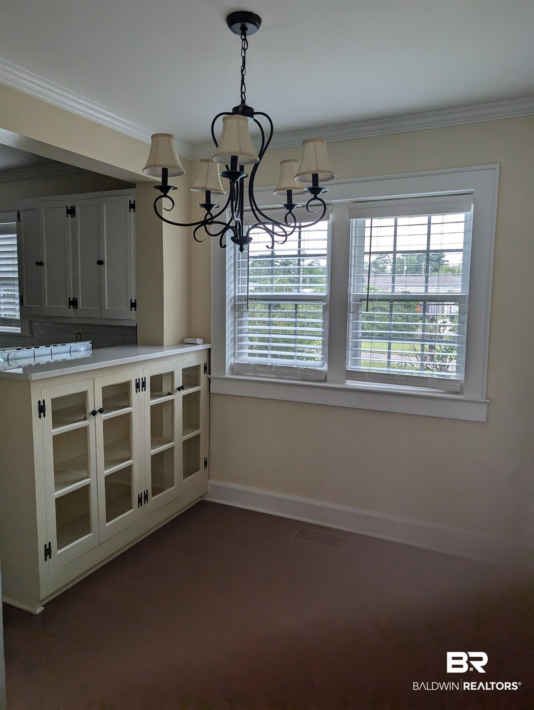 1405 Escambia Avenue Brewton, AL 36426 - Photo 7 of 16 Unfurnished dining area with a chandelier, ornamental molding, and dark carpet