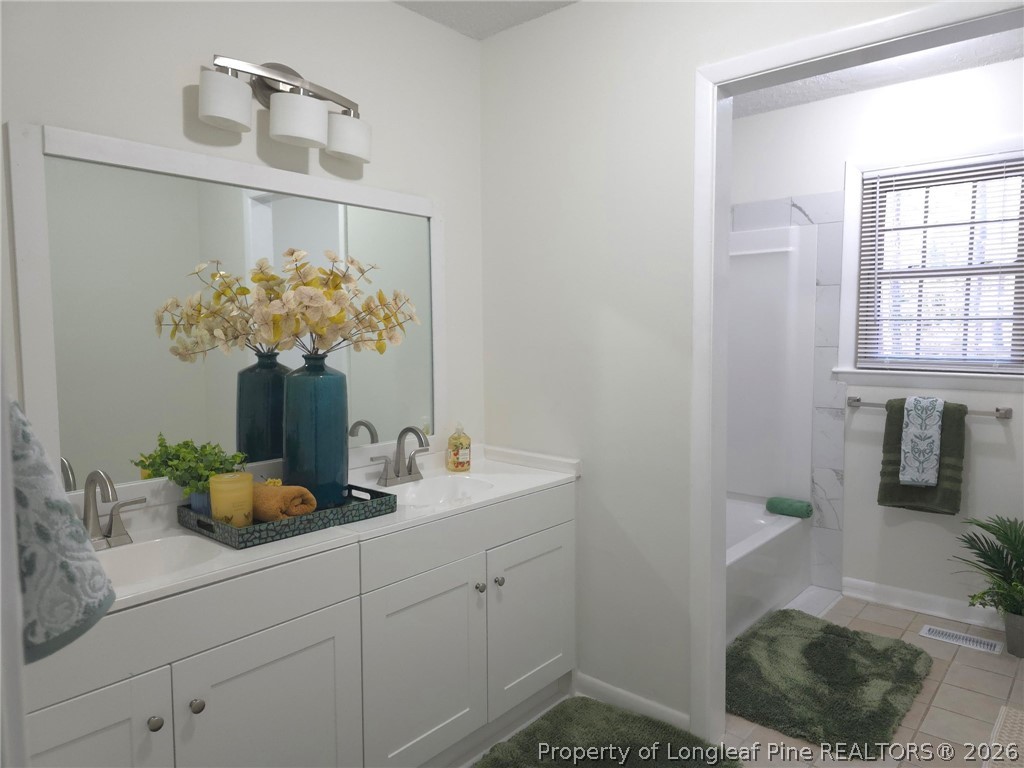 5945 Muscat Road Hope Mills, NC 28348 - Photo 17 of 36 a bathroom with a sink a toilet and mirror