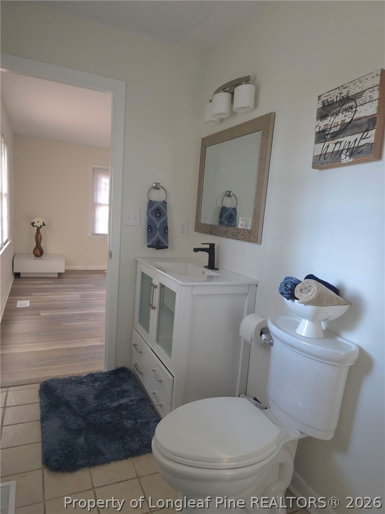 5945 Muscat Road Hope Mills, NC 28348 - Photo 23 of 36 a bathroom with a toilet a sink and mirror