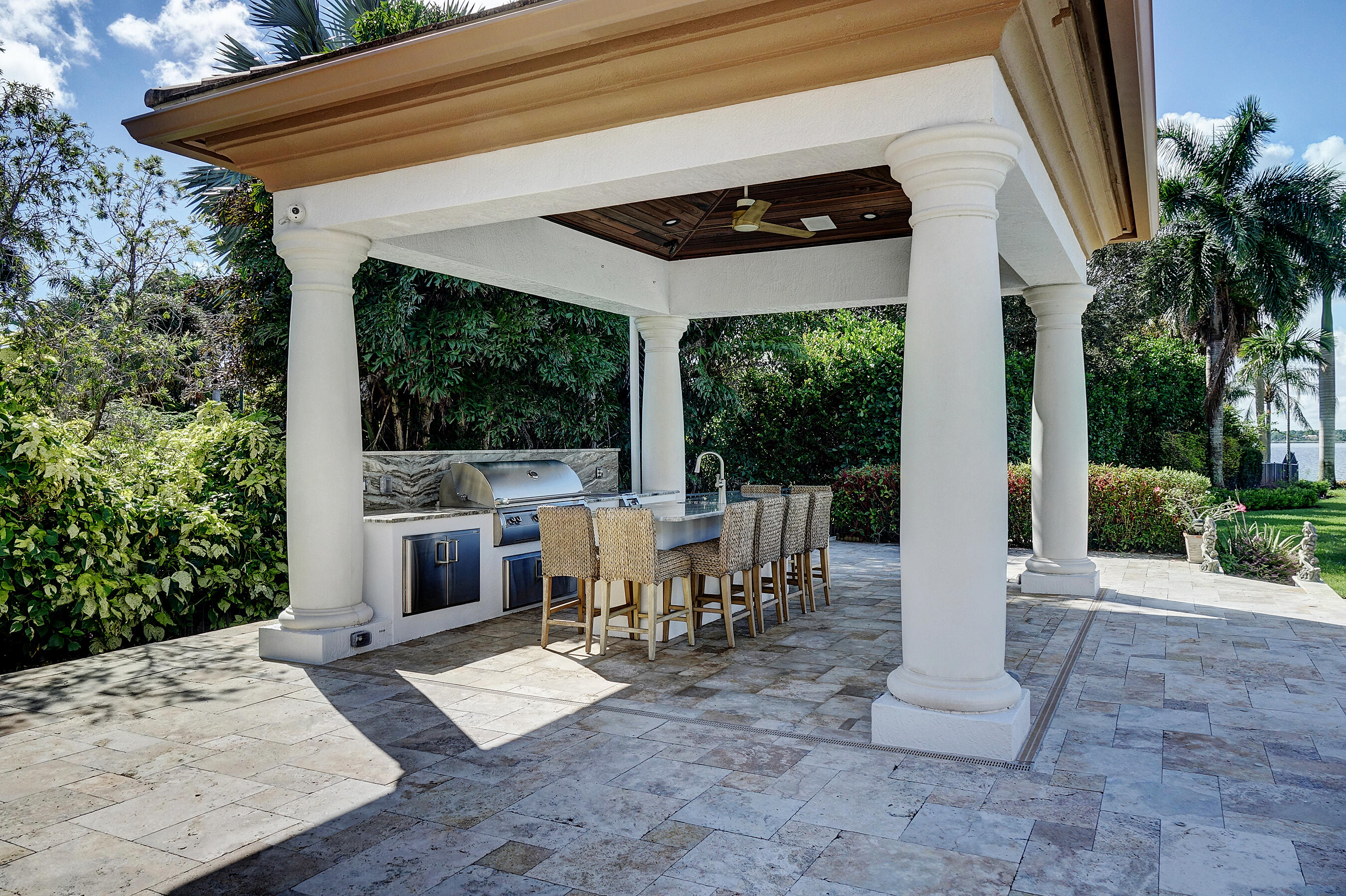 2690 Northwest Collins Cove Road Stuart, FL 34994 - Photo 52 of 78 a view of a patio with a dining table and chairs with wooden floor and fence