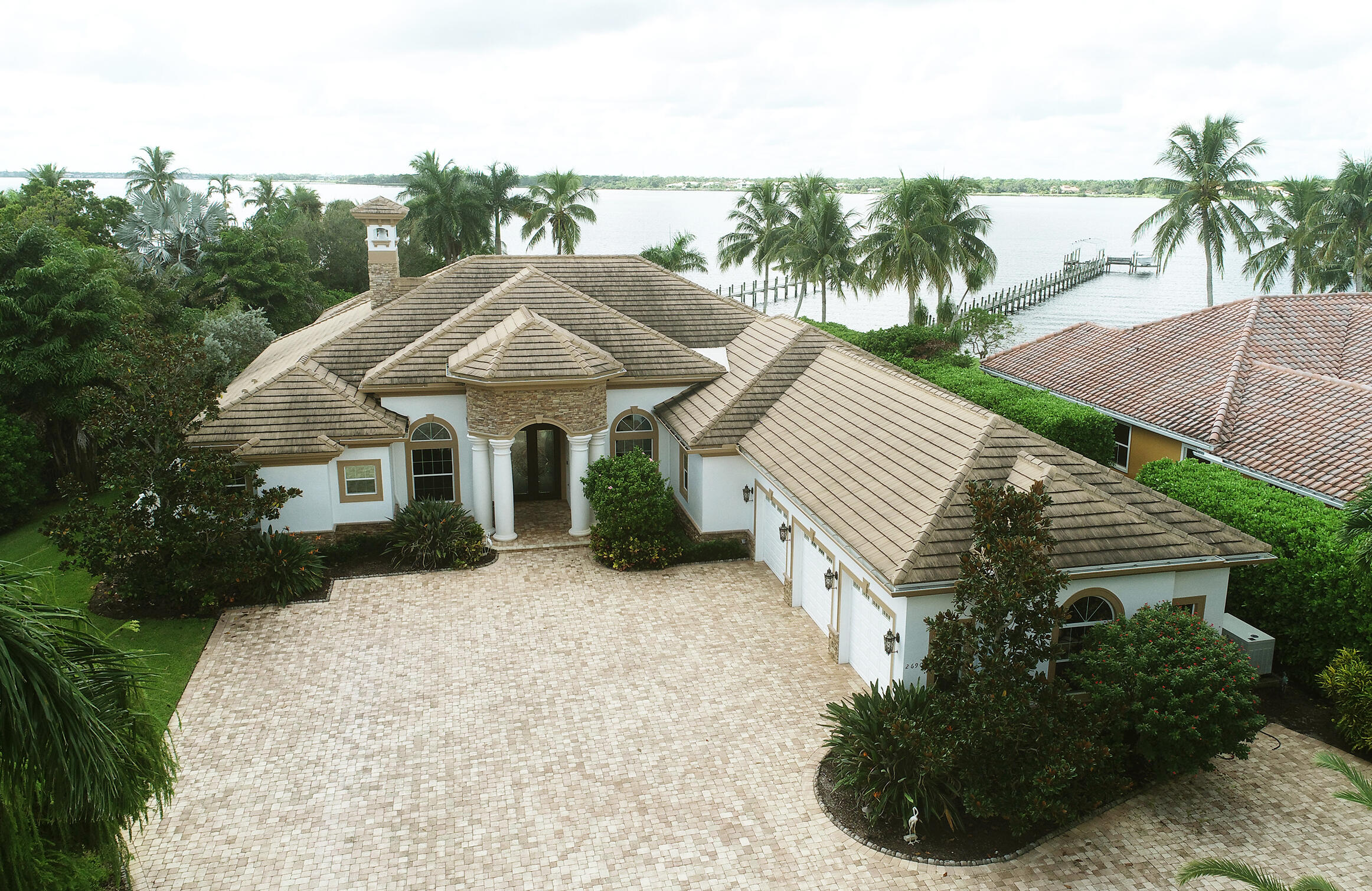 2690 Northwest Collins Cove Road Stuart, FL 34994 - Photo 62 of 78 a front view of a house with a yard and potted plants