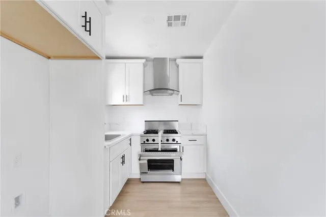 a kitchen with cabinets stainless steel appliances and a window