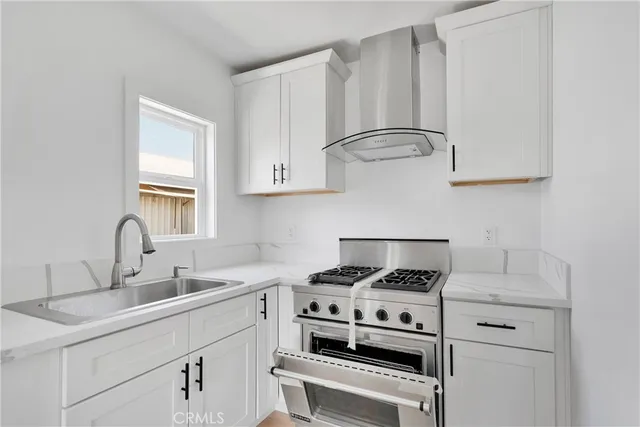a kitchen with appliances a sink and cabinets