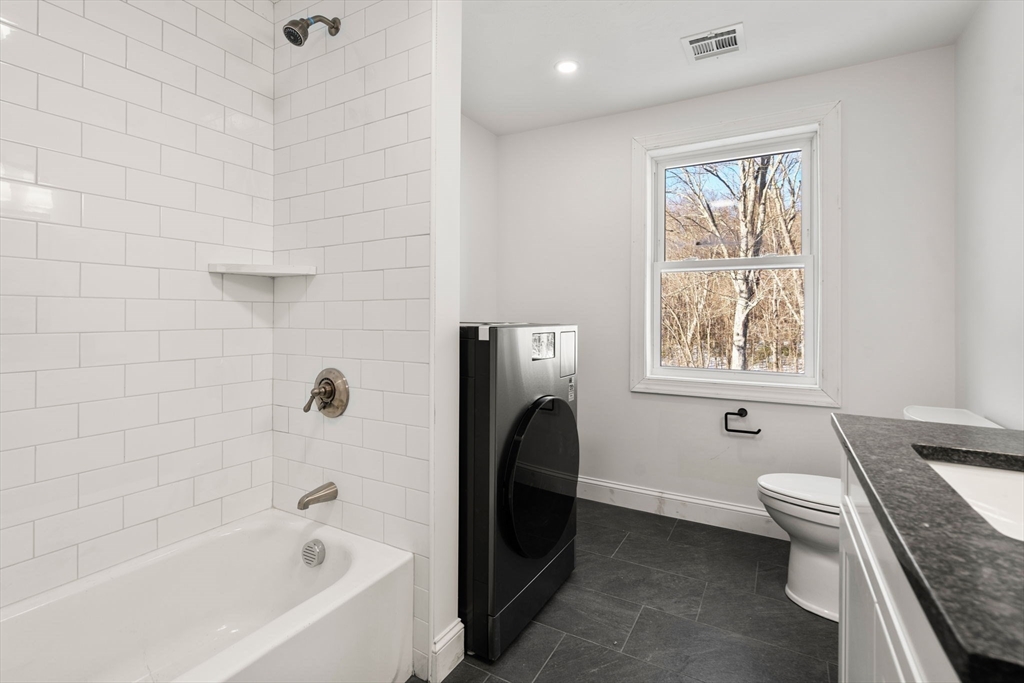 99 Main Street, Unit A Upton, MA 01568 - Photo 17 of 21 a bathroom with a granite countertop bathtub sink vanity and toilet