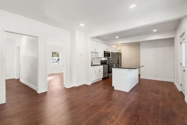a view of an empty room with wooden floor