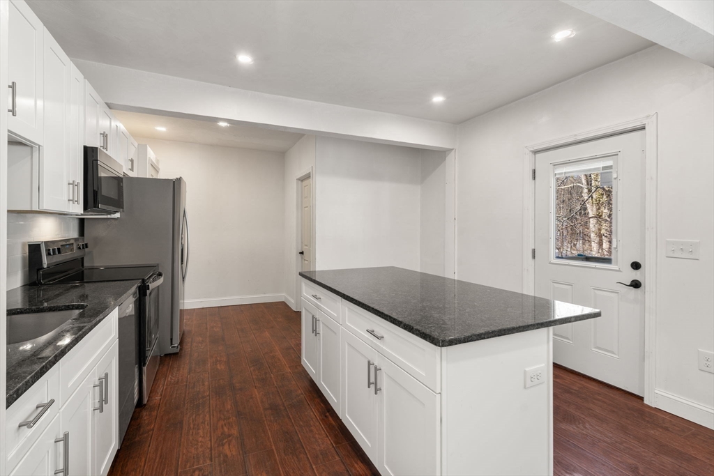 99 Main Street, Unit A Upton, MA 01568 - Photo 6 of 21 a kitchen with stainless steel appliances granite countertop a sink dishwasher a refrigerator and a stove with wooden floor