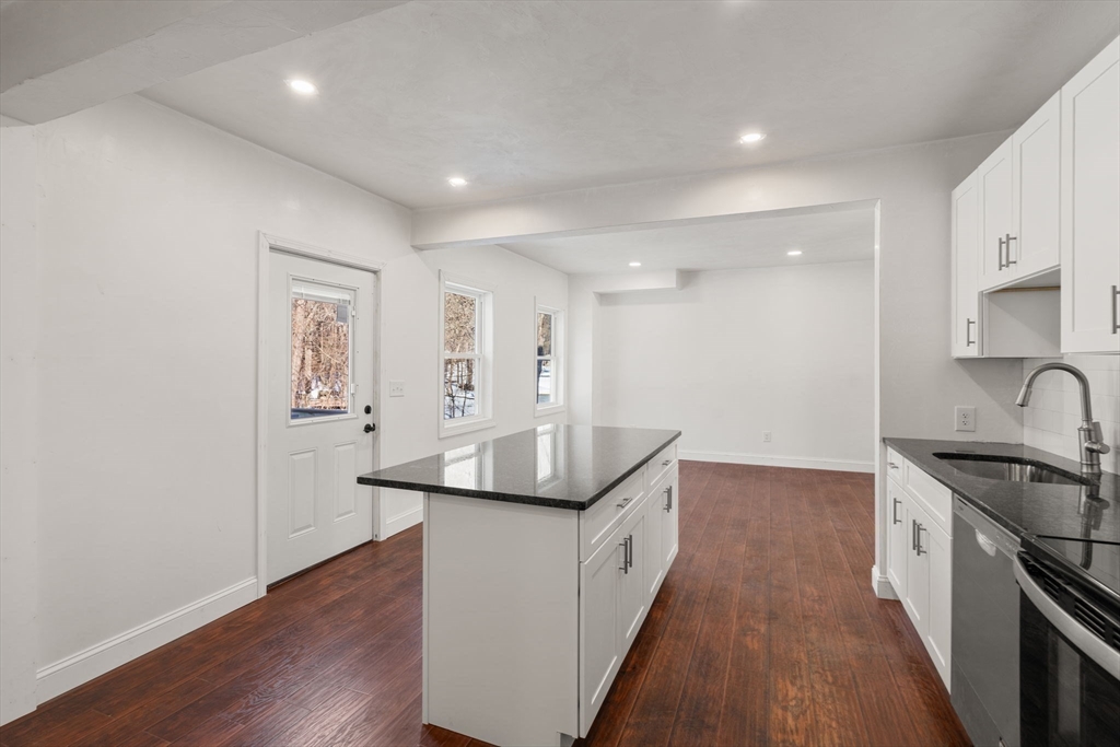 99 Main Street, Unit A Upton, MA 01568 - Photo 7 of 21 a kitchen with stainless steel appliances granite countertop a sink and a stove top oven