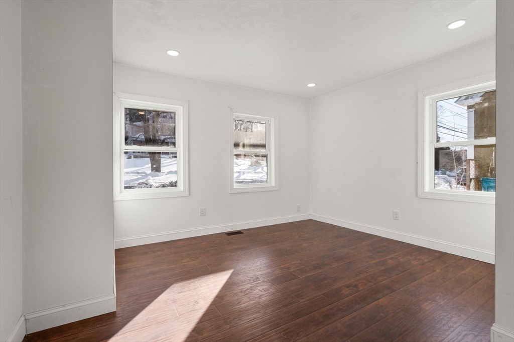 99 Main Street, Unit A Upton, MA 01568 - Photo 8 of 21 an empty room with wooden floor and windows