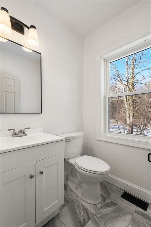 99 Main Street, Unit A Upton, MA 01568 - Photo 10 of 21 a bathroom with a toilet a sink a vanity and mirror