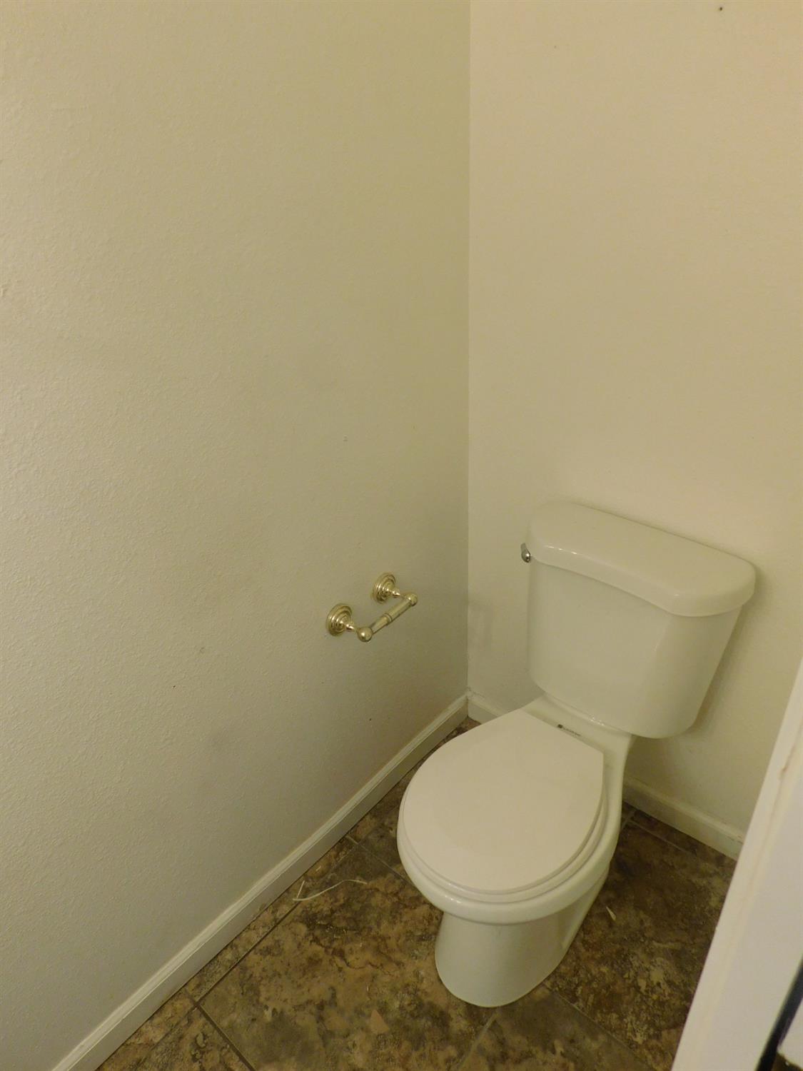 2316 Mountain Quail Way Modesto, CA 95355 - Photo 38 of 49 a white toilet sitting next to a white wall
