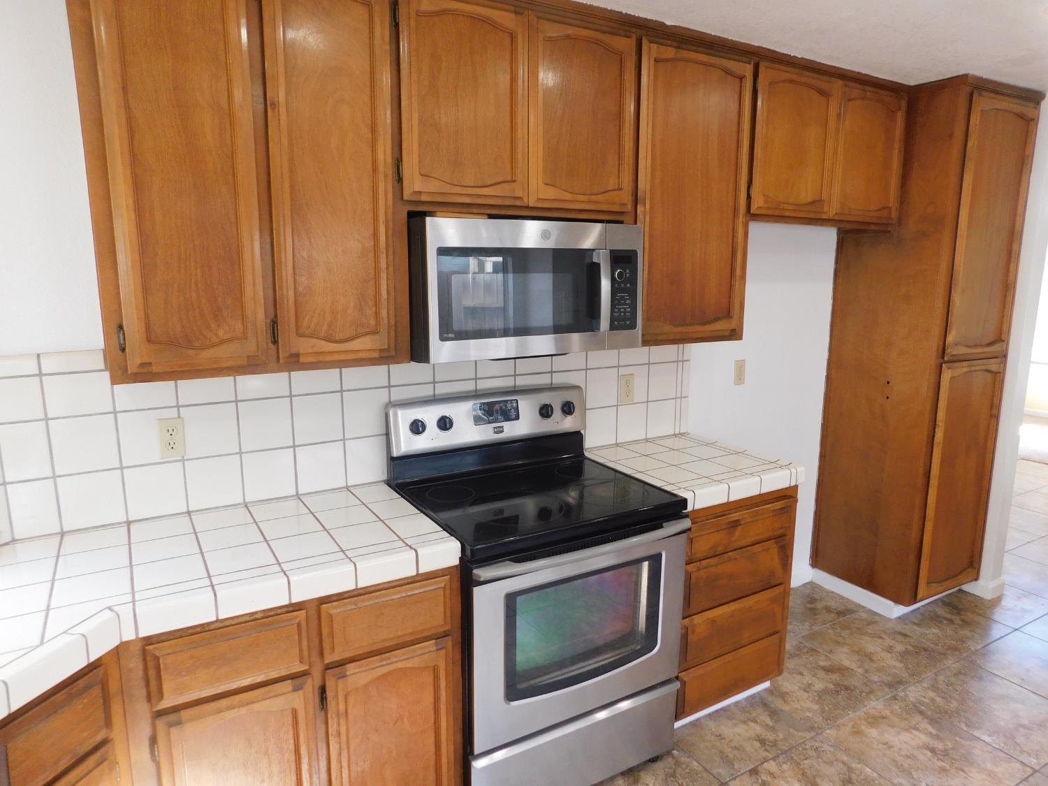 2316 Mountain Quail Way Modesto, CA 95355 - Photo 10 of 49 a kitchen with granite countertop wooden cabinets and stainless steel appliances