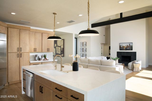 a kitchen with stainless steel appliances a dining table chairs and white cabinets