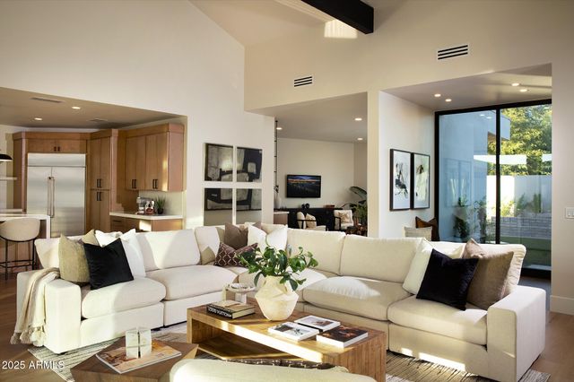 a kitchen with stainless steel appliances granite countertop a sink a refrigerator and chairs