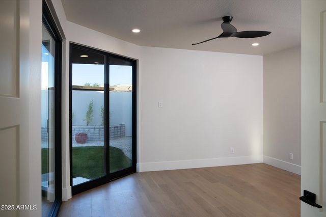 a view of a room with a large window and hardwood floor
