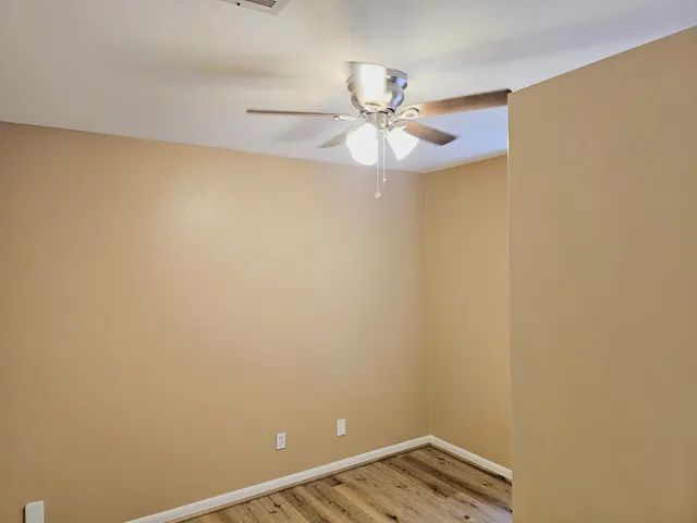 an empty room with wooden floor and entrance