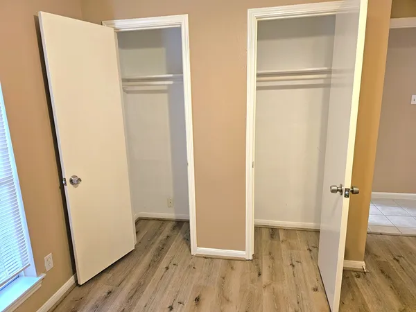 an empty room with wooden floor and entrance