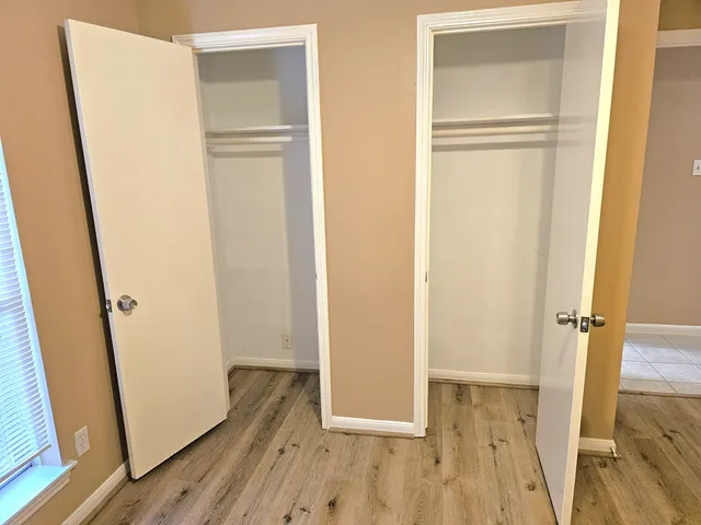 a view of a room with wooden floor and a window