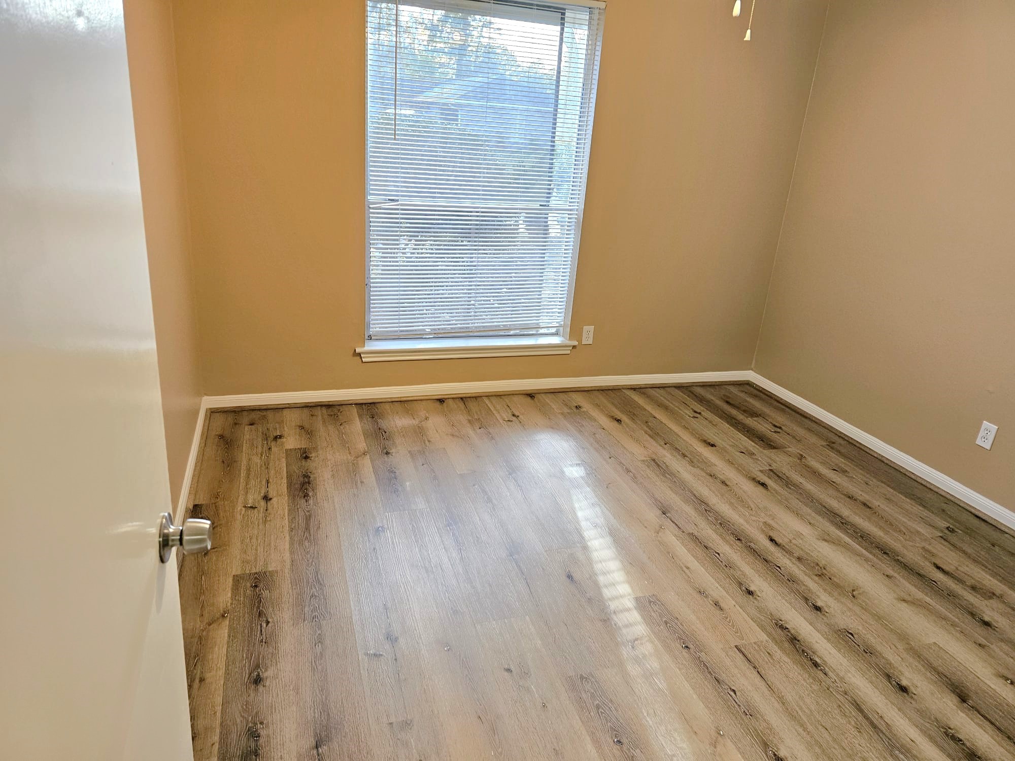 2327 Shadbury Court Houston, TX 77339 - Photo 30 of 32 a view of an empty room with wooden floor and a window
