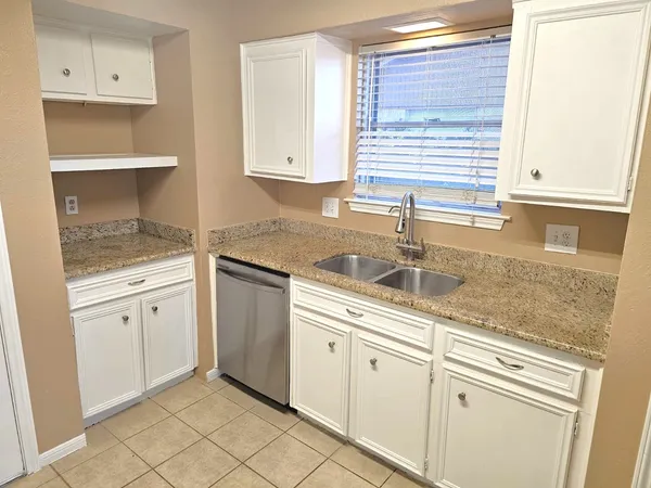 a kitchen with granite countertop white cabinets and white appliances