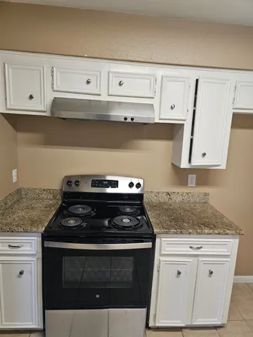 a stove top oven sitting inside of a kitchen