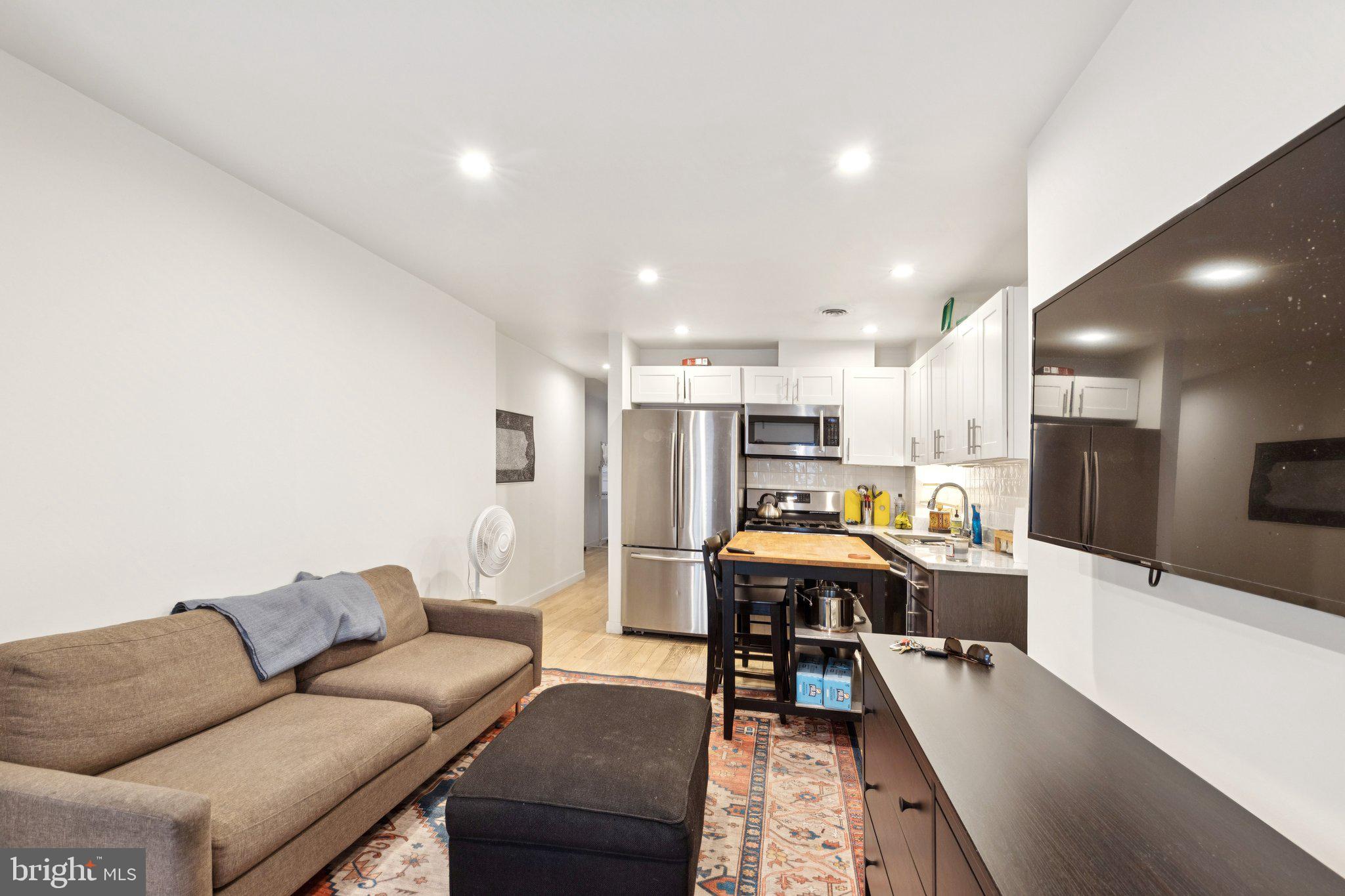 618 South 21st Street Philadelphia, PA 19146 - Photo 2 of 16 a living room with stainless steel appliances kitchen island dining table and a couch