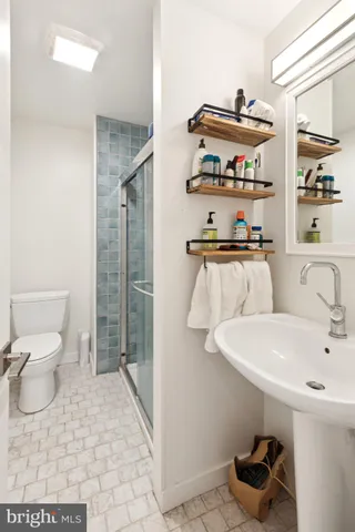 a bathroom with a sink a toilet and shower