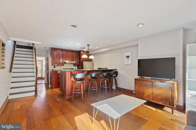 a living room with furniture a flat screen tv and kitchen view