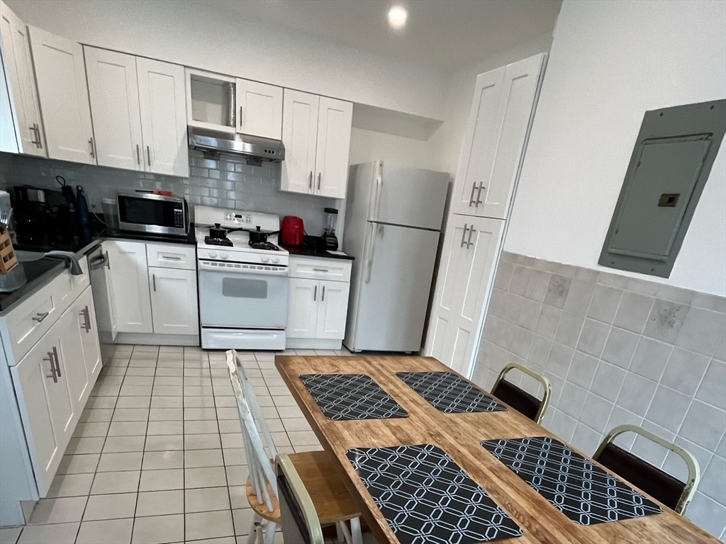 22 Marcella Street, Unit 2 Cambridge, MA 02141 - Photo 2 of 9 a kitchen with a stove a refrigerator and cabinets