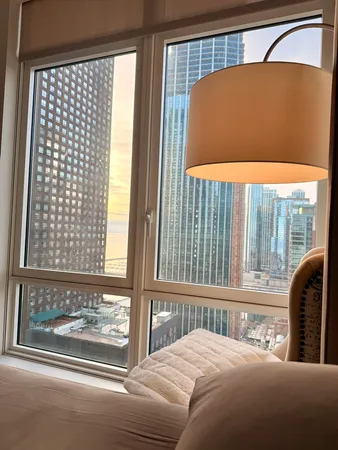 a bedroom with a large window and a balcony view