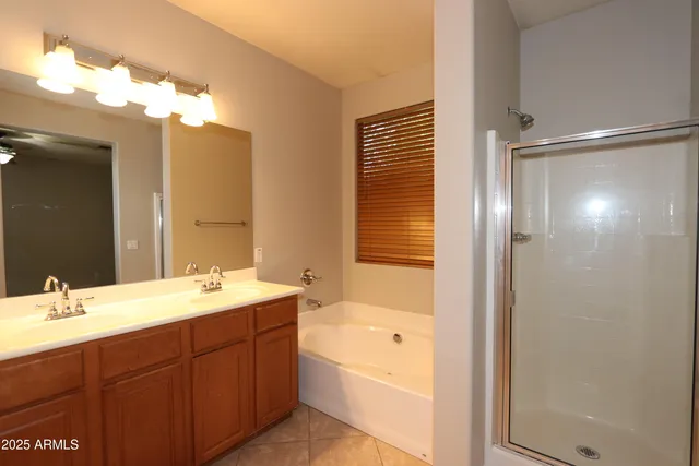 a bathroom with a double vanity sink mirror and shower