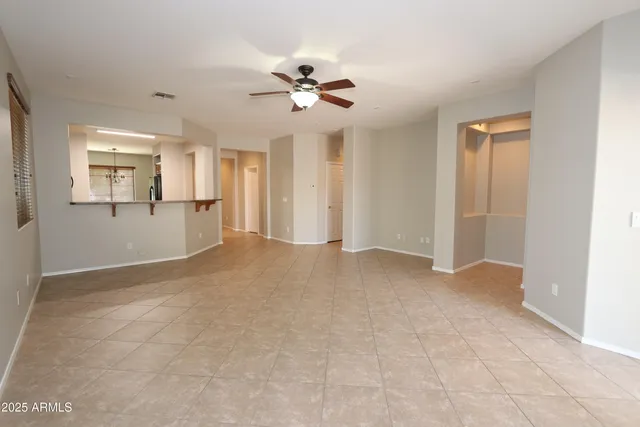 a view of a livingroom with a chandelier fan and windows