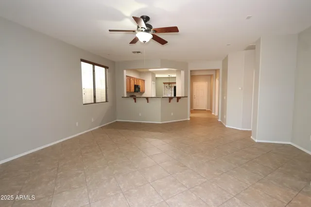 a view of a livingroom with a ceiling fan and window