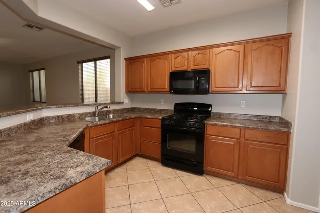 a kitchen with granite countertop a sink and a stove top oven