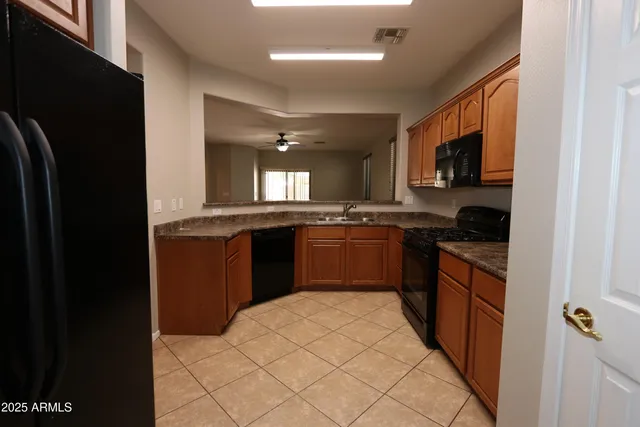 a kitchen with stainless steel appliances granite countertop a stove a sink and a refrigerator
