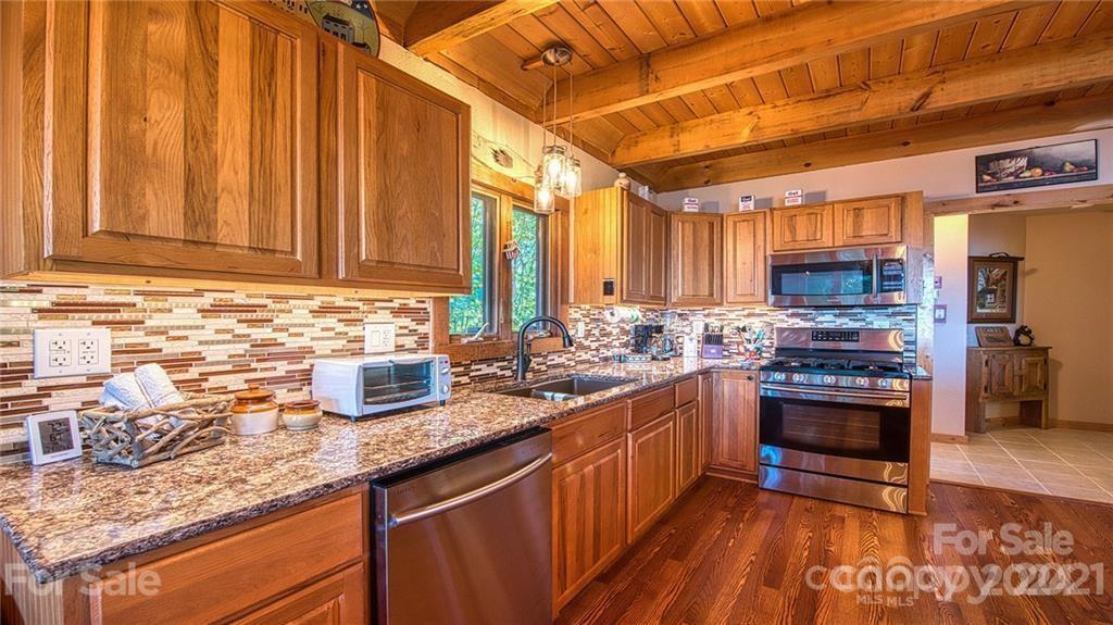 135 Aerial Ridge Waynesville, NC 28785 - Photo 21 of 27 a kitchen with stainless steel appliances granite countertop a stove a sink and a microwave