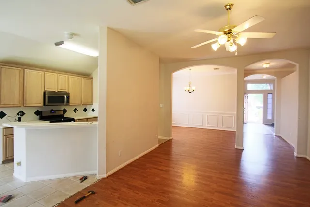 a view of a kitchen with a sink a microwave and wooden floor