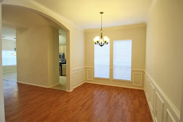 a view of a room with wooden floor table and chairs