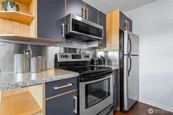 a kitchen with stainless steel appliances granite countertop a stove and a microwave